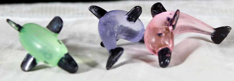 Miniature hardened plastic dolphin trio