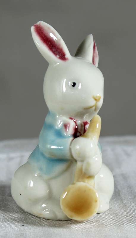 Miniature glazed ceramic bunny eating a carrot