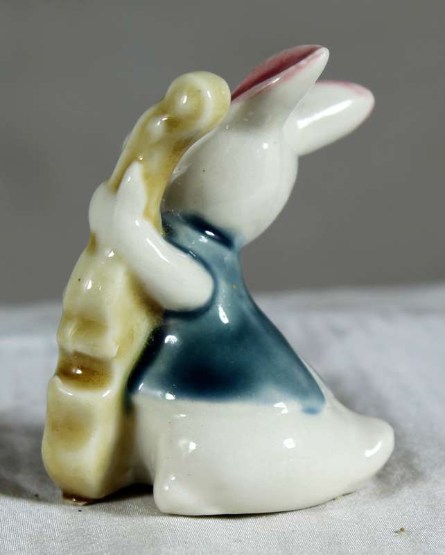 Miniature glazed ceramic bunny playing a bass