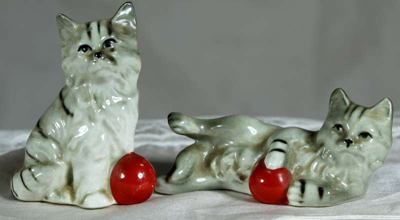 Pair of cats playing with red balls