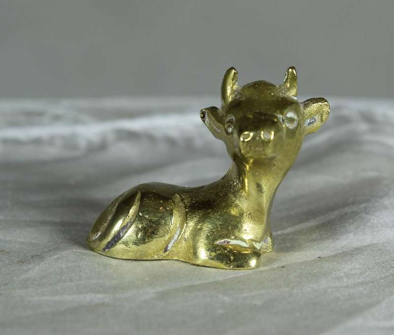 Miniature brass cow lying down