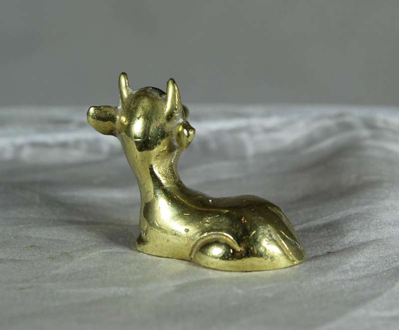 Miniature brass cow lying down