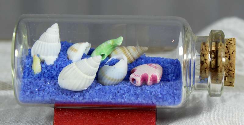 Miniature shells and blue sand in bottle