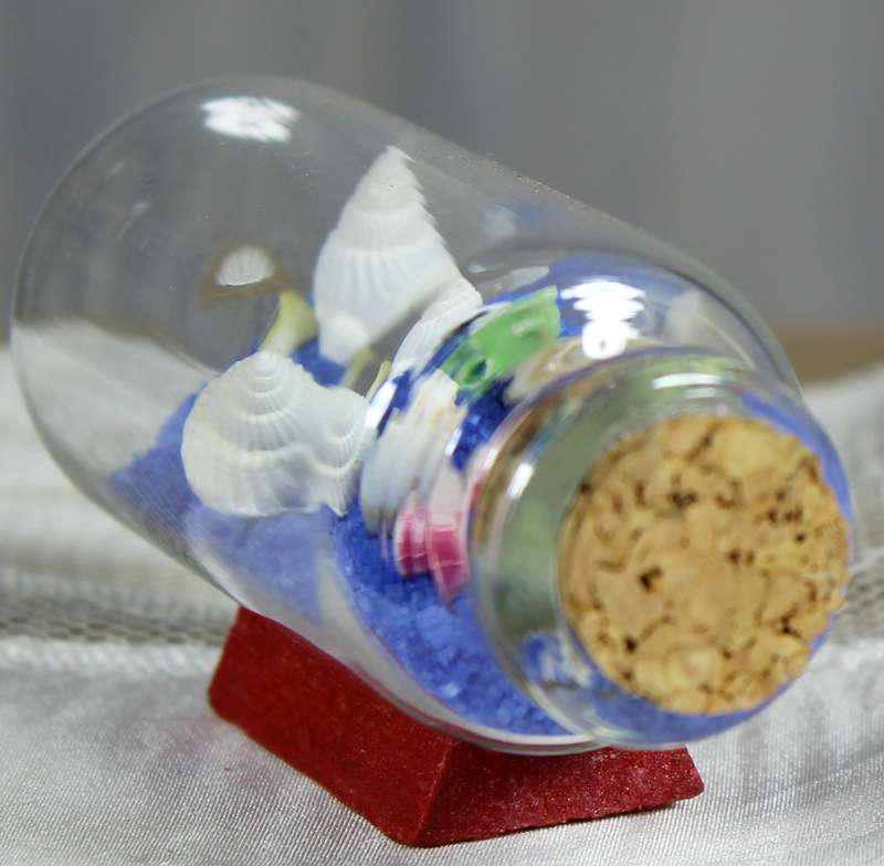 Miniature shells and blue sand in bottle