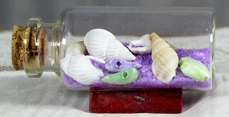 Miniature shells and purple sand in bottle
