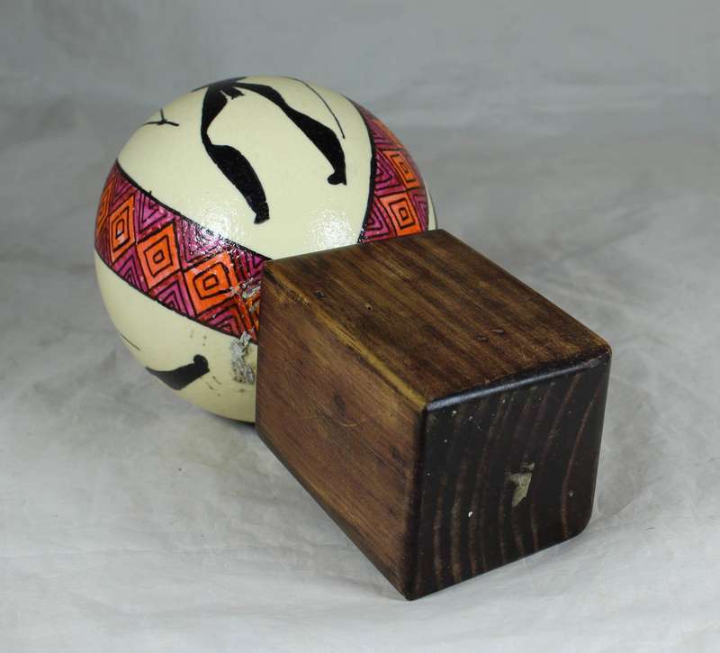Painted ostrich egg on a wooden base