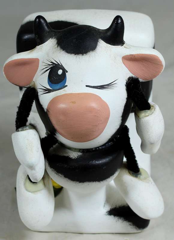 Ceramic cow sitting on the toilet