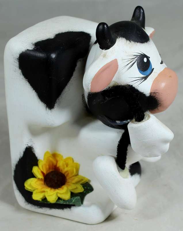 Ceramic cow sitting on the toilet