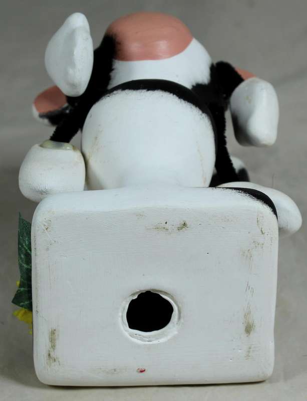 Ceramic cow sitting on the toilet