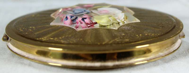 Encased flowers in golden powder compact