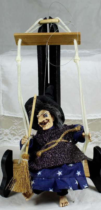 Witch with a broom on a swing