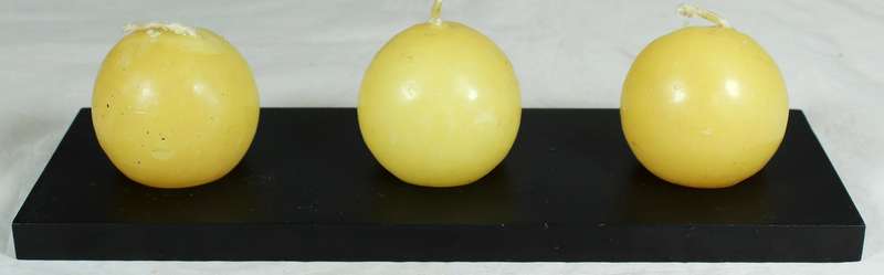 Three round candles on a plinth