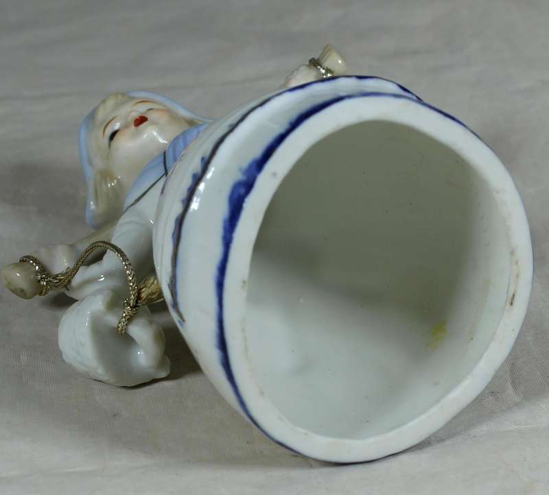 Porcelain bell with girl holding two baskets