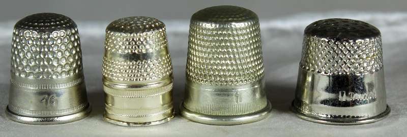 Four silver colored thimbles