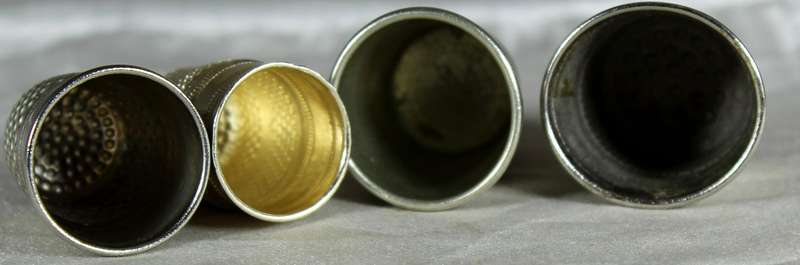Four silver colored thimbles