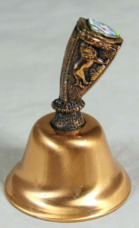 Souvenir copper bell - Umhlanga rock with lion topped figure embossed to shield