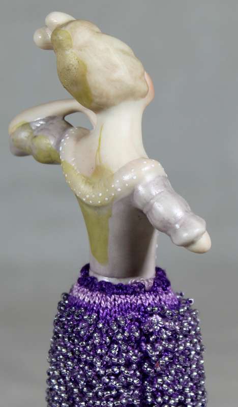 Half doll with beaded purple dress on stand