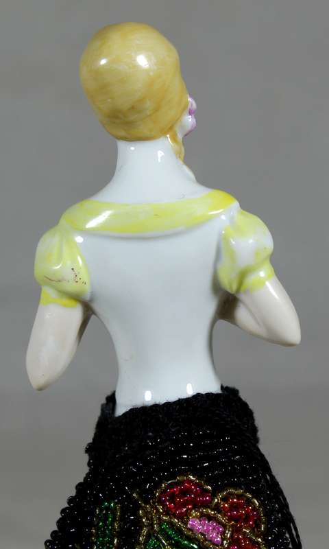 Half doll with beaded black dress on stand