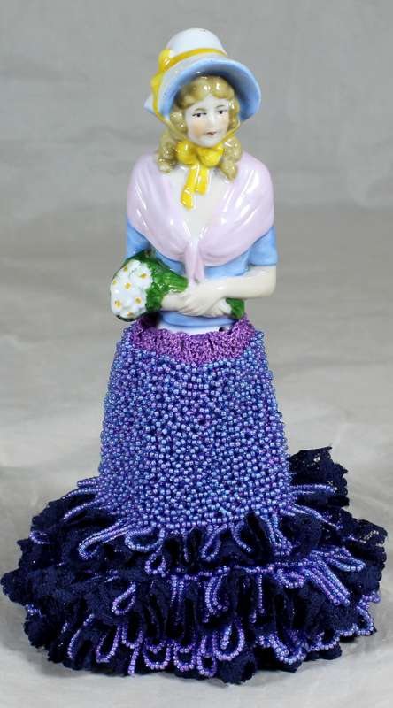 Half doll with beaded purple & black dress on stand