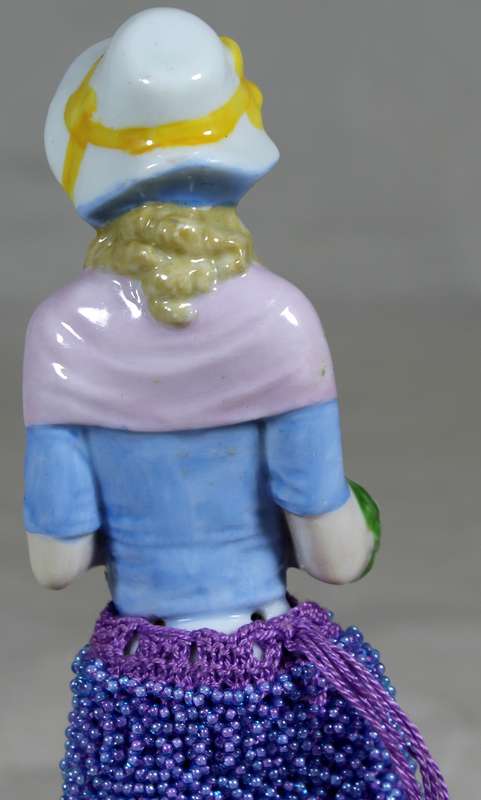 Half doll with beaded purple & black dress on stand