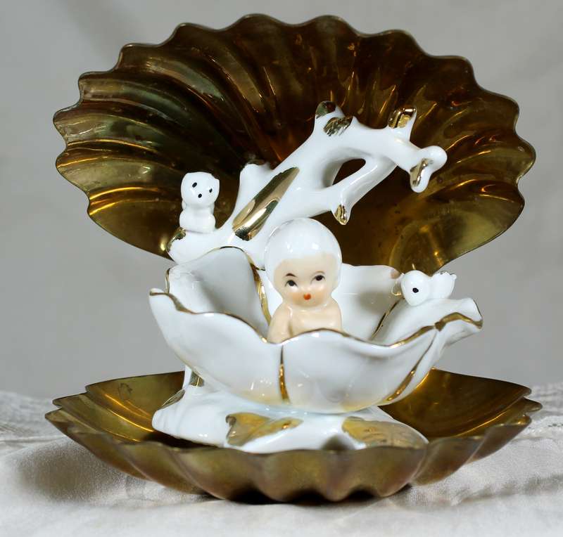 Porcelain baby in brass clam shell