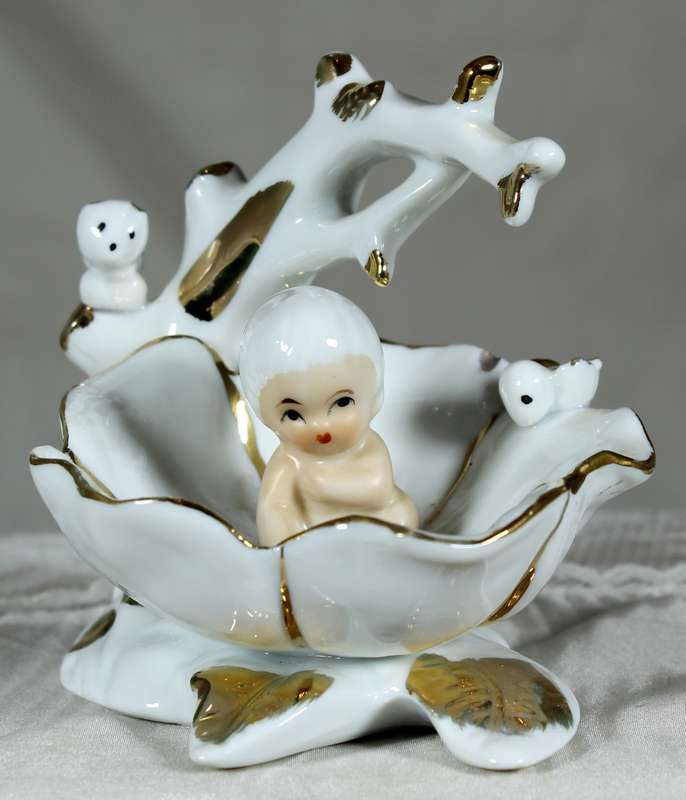 Porcelain baby in brass clam shell