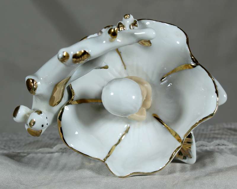Porcelain baby in brass clam shell
