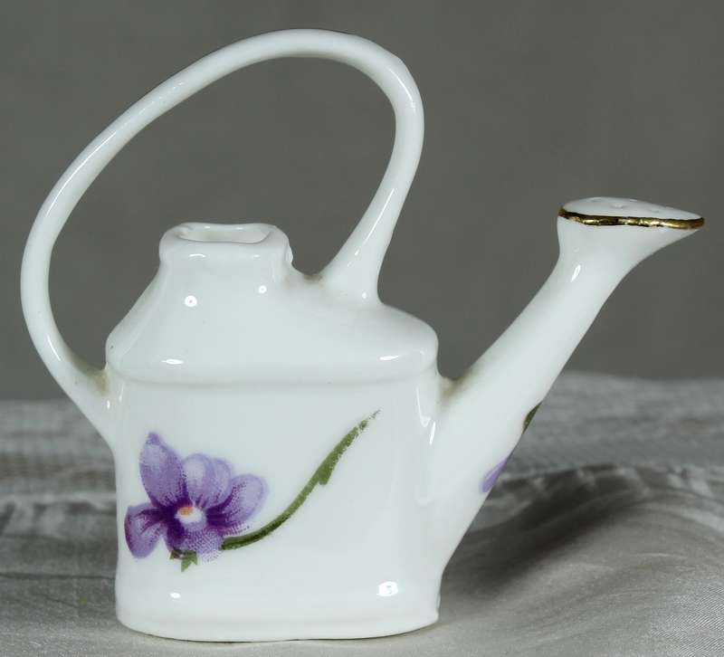 Miniature watering can with purple violets