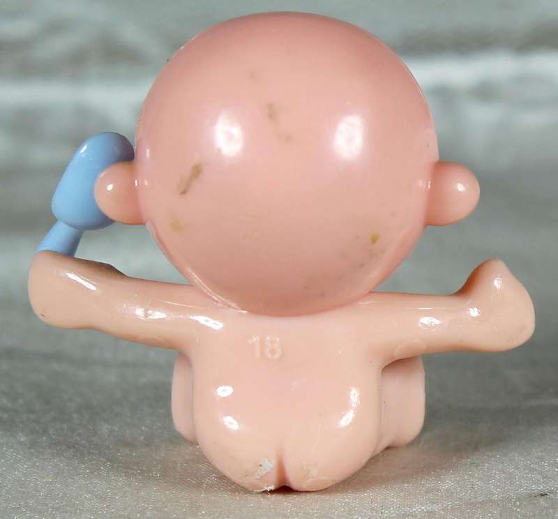 Miniature plastic baby with dummy and spoon