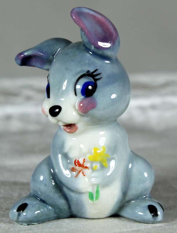 Miniature bunny holding flowers