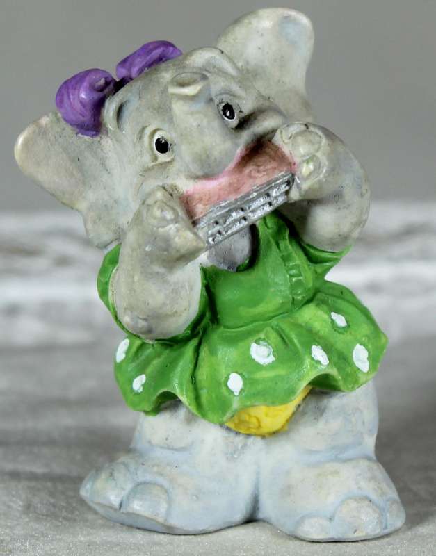 Miniature elephant playing a harmonica