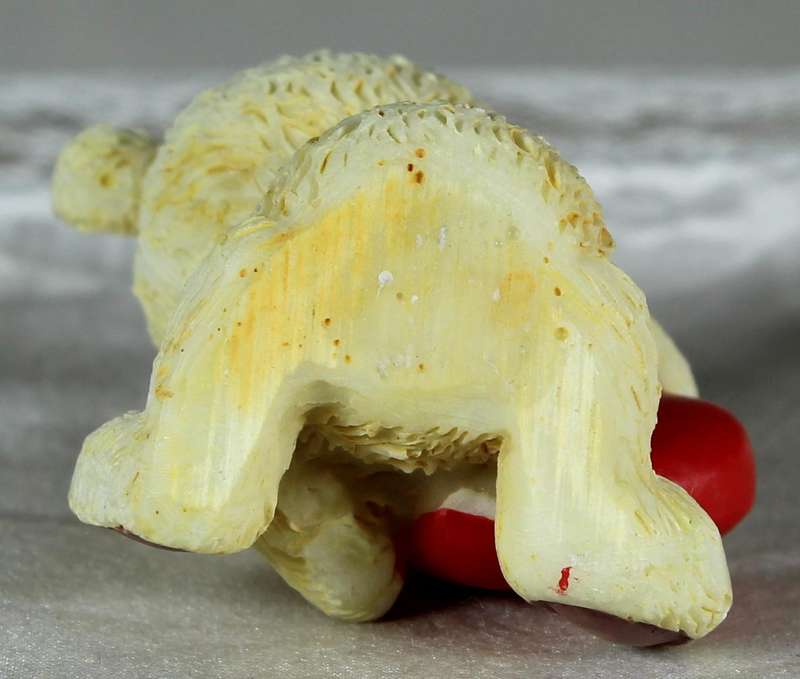 Miniature teddy bear holding a large heart