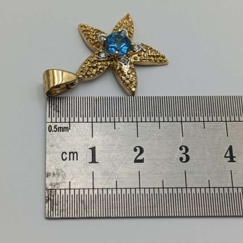 14kt Yellow gold starfish pendant with light blue topaz and small diamonds - weighs 3,2g