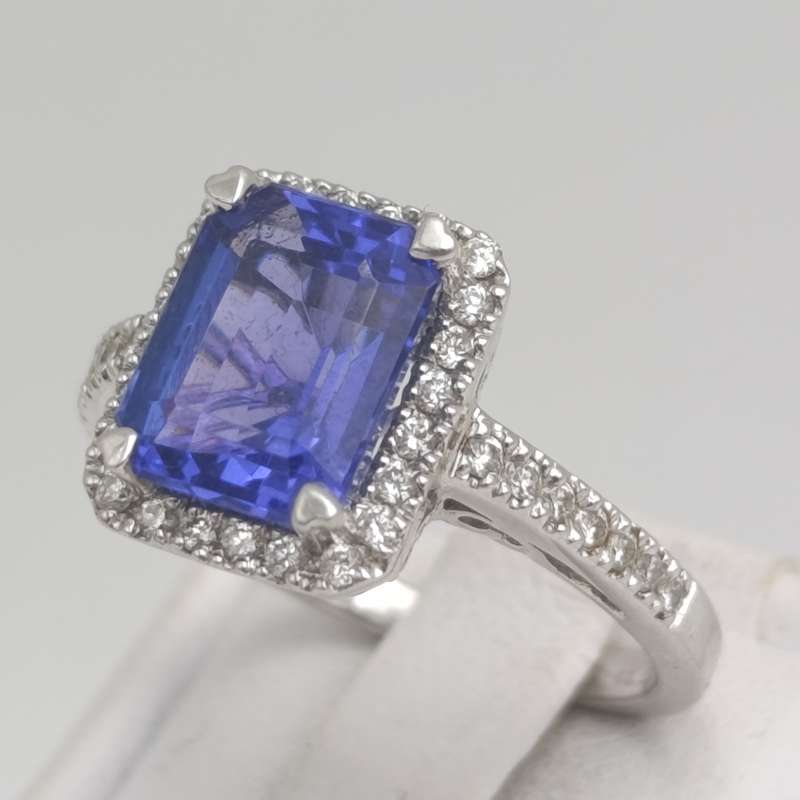 18kt White ring with blue stone surrounded by small diamonds - weighs 6.2 grams - size N 1/2