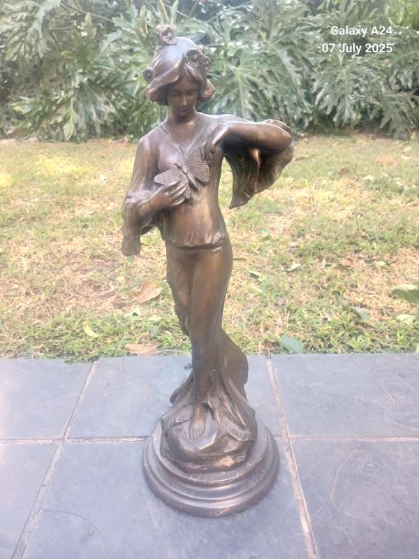 Bronze figurine of a lady holding a butterfly