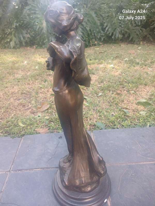 Bronze figurine of a lady holding a butterfly