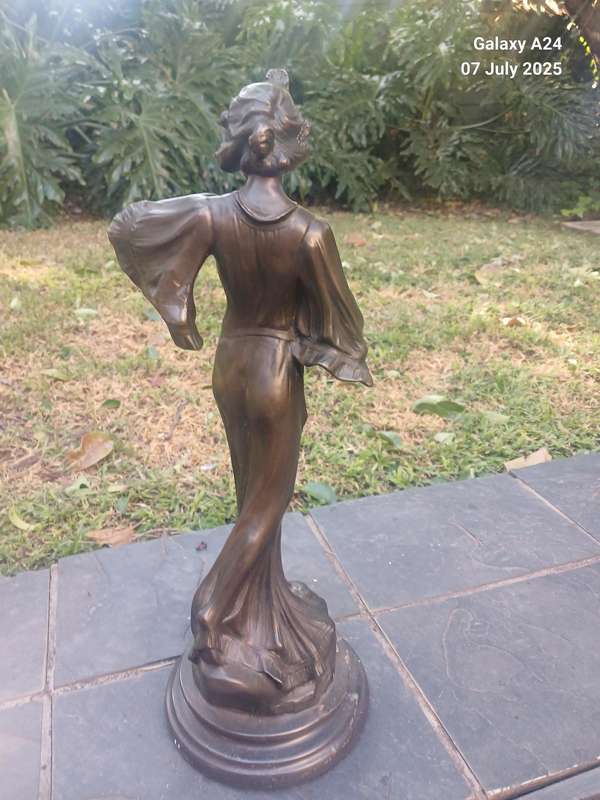 Bronze figurine of a lady holding a butterfly