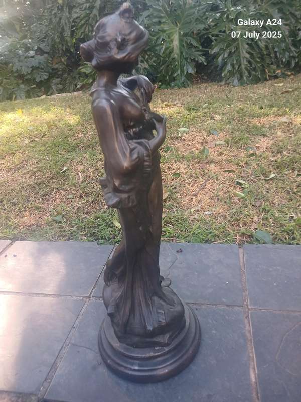 Bronze figurine of a lady holding a butterfly