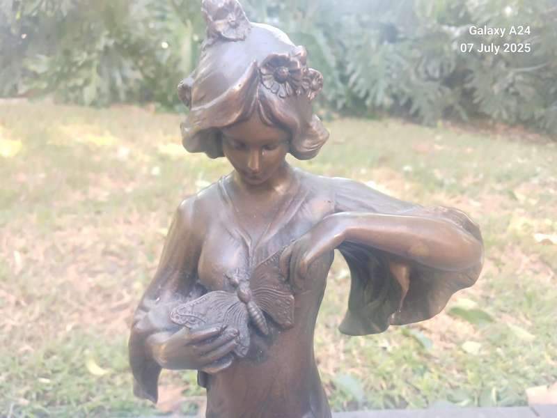 Bronze figurine of a lady holding a butterfly