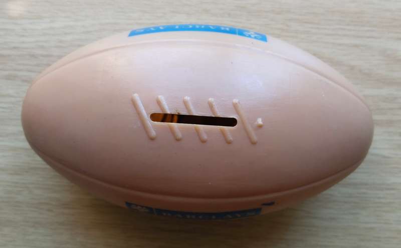 Barclays Bank old savings rugby ball with coins.