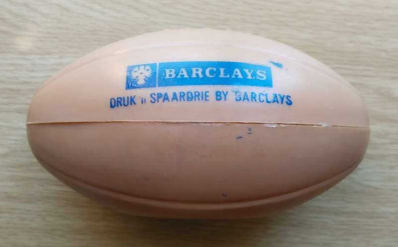 Barclays Bank old savings rugby ball with coins.
