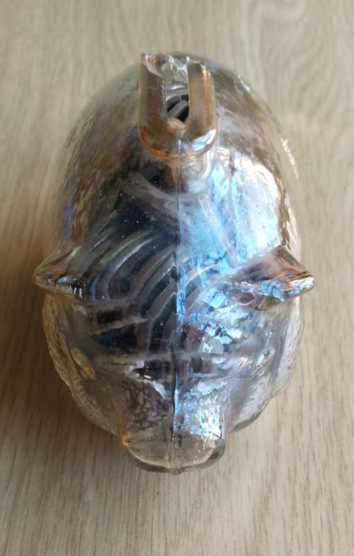 Glass piggy bank sealed full of mystery coins. Top chipped.
