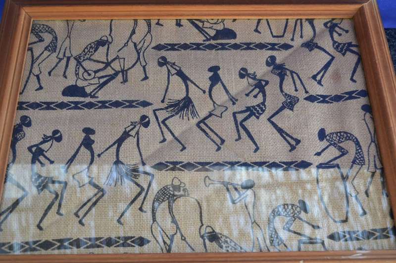 Black silhouette ethnic style stick figure art on quilted sacking