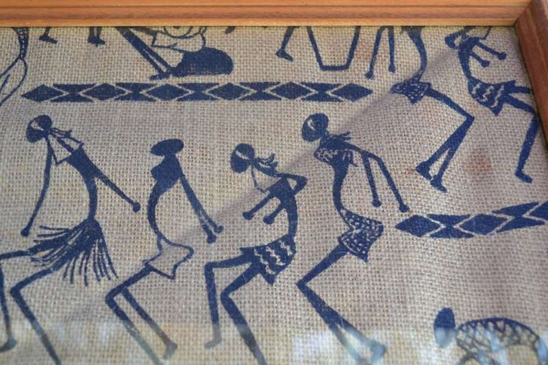 Black silhouette ethnic style stick figure art on quilted sacking