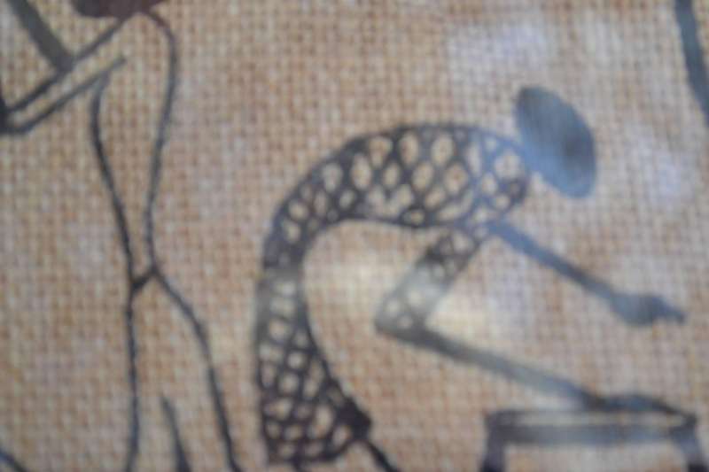 Black silhouette ethnic style stick figure art on quilted sacking