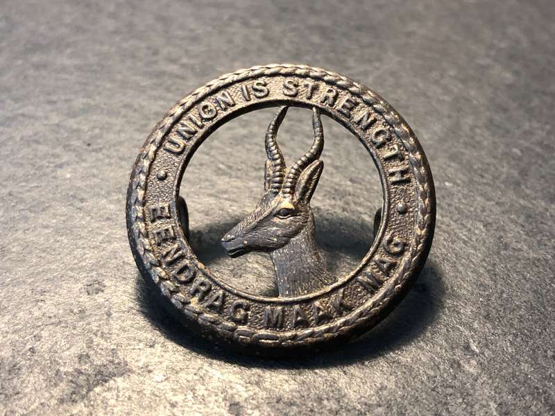 Bronze South African "Union is Strength/Eendrag Maak Mag" badge with Springbok