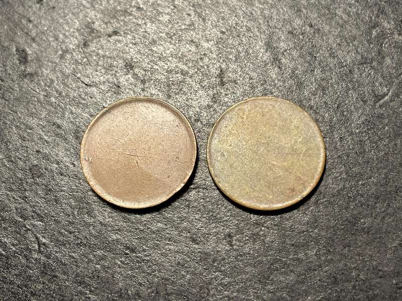 Two unidentified blank coin planchets - roughly the size of a 1 cent