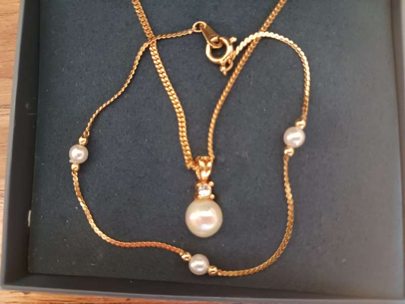 A 22 carat gold plated necklace with pearl and simulated diamond pendant,plus a bracelet.