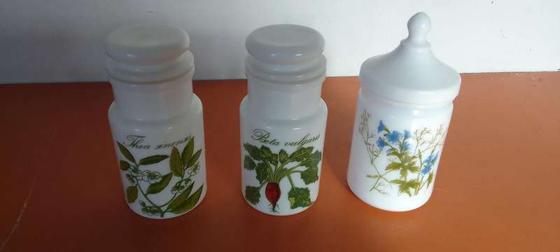 A Collection Of Milk Glass Containers With Lids