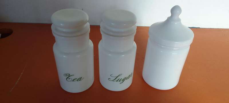 A Collection Of Milk Glass Containers With Lids